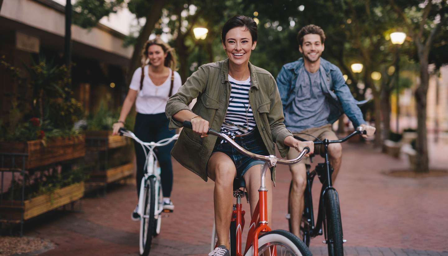 Three young people cycling down the street